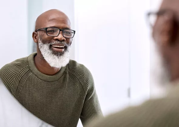 Older man looking at smile in mirror